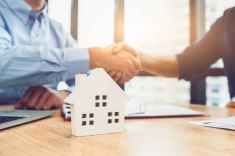 A mortgage loan officer shaking hands with a new home owner