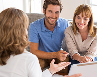 a young couple meeting with a realtor